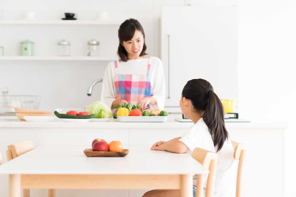 オープンキッチン越しに親子が会話している写真